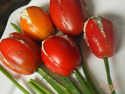 Готово! В каждый помидор вставить зубочистки,на них надеть стебли зелёного лука.На блюдо выложить листья щавеля,распределить помидорные тюльпаны,сделать бант из красного болгарского перца.Приятного аппетита!!!!
