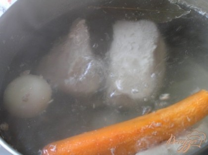 Свинину промыть, выложить в кастрюлю, залить 2 литрами воды, поставить на сильный огонь, довести до кипения, добавить луковицу с воткнутыми в нее гвоздичками и целую морковь. Варить 1,5 часа.