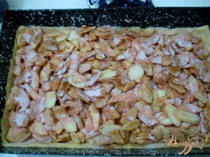 На тесто порезанные яблоки, а на них рассыпьте половину пачки сухого киселя.