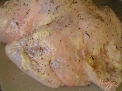 Сливочное масло со специями равномерно распределить под кожу курицы. Внутри и немного снаружи курицу посыпать оставшейся солью.