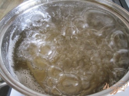 Приготовить сахарный сироп. Сахар залить водой  и поставить на средний огонь, добавить цедру с лимонов, уварить до "мягкого шарика".