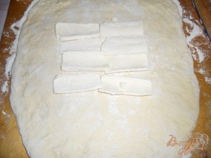 Раскатываем тесто в пласт,по середине кладем треть масла.