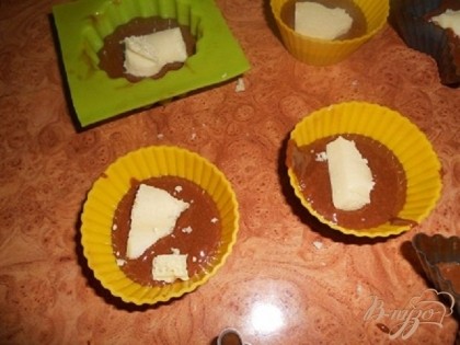 формы на половину наполнить тестом,сверху положить по ломтику белого пористого шоколада.