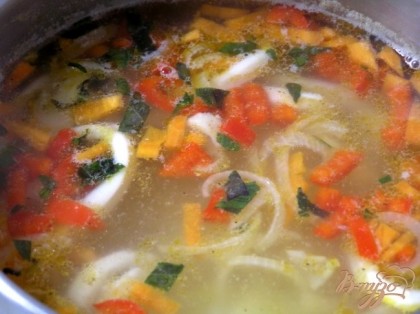 В кастрюлю добавить обжаренные овощи и кальмары, посолить по вкусу, готовить еще около 10 минут.
