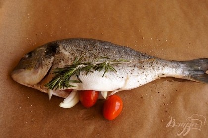Натереть рыбу смесью соли и перца. В брюшко каждой рыбы, положить по веточке розмарина, помидорки, лук. Противень застелить пекарской бумагой, разложить рыбу, сверху накрыть плотно фольгой .Отправить в разогретую духовку на 20 минут при 230г