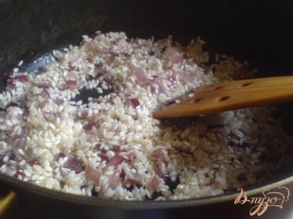 Всыпать рис и обжарить его в течение 5 минут постоянно помешивая.