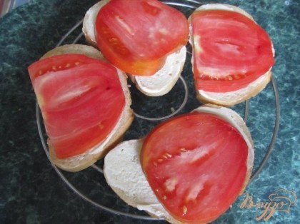 Крупный, мясистый помидор нарезать кружочками. Выложить на хлеб.