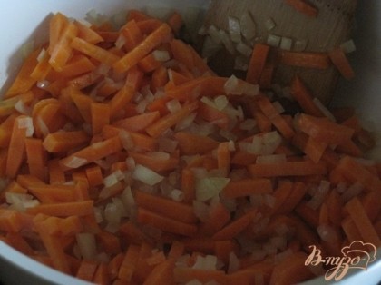 В сотейнике слегка пассировать лук, добавить морковь и продолжать обжаривать на сильном нагреве.