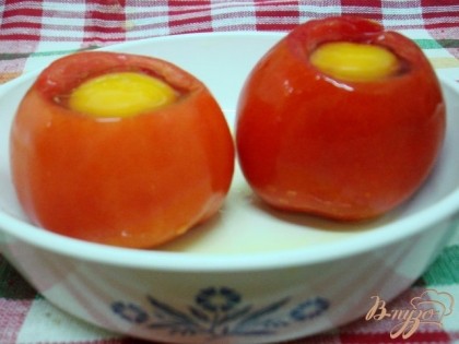 Сковородку смазать маслом, поставить помидоры.Внутри посолить и выбить по яйцу. Если помидоры крупные под яйцо можно положить порезанную ветчину.