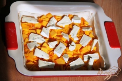 Тыкву режем небольшими тонкими кусочками и укладываем на тесто.Сверху распределить сыр.