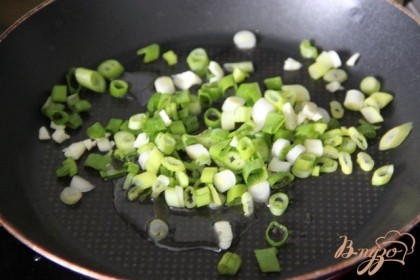 Зелёный лук нарезать колечками и слегка подрумянить на разогретом масле вместе с мелконарезанным чесночком.
