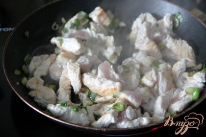 Мясо грудки индейки нарезать полосками и добавить на сковороду к луку. Жарить, помешивая.