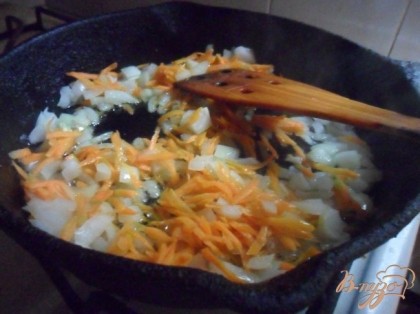 В сковороде разогреть растительное масло, обжарить морковь с луком до золотистого цвета.
