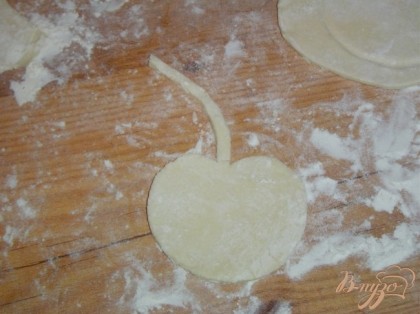 Раскатываем слоеное тесто и с помощью шаблона вырезаем вишенки и листочки.