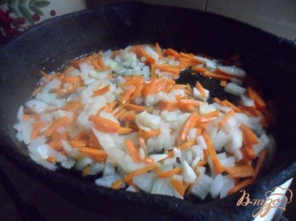 В сковороде разогреть растительное масло. Обжарить на нём лук и морковь до золотистого цвета.
