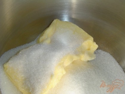 Начинка готова, и мы приступаем к приготовлению коржей. Размягченное масло взбиваем до бела с сахаром, а затем по одному добавляем яйца и взбиваем до однородного состояния.