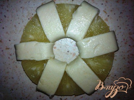 Размороженное тесто, разрезаем на полосочки и через кольцо заворачиваем на ананас. Из остатков теста лепим кружочек и кладем в серединку ананаса
