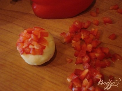 Измельчаем красный сладкий перец и наносим его на картофельные шарики.