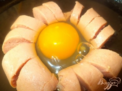 сосиску крутим в баранку, в полученный кружок разбиваем яйцо и жарим 5 минут на сковородке с добавлением растительного масла под крышкой
