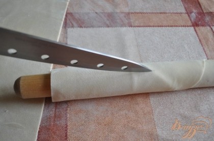 Разрезать пласт на 2 половины и намотать на скалку,как указано на фото,провести ножом по середине ,разделив тесто на части,
