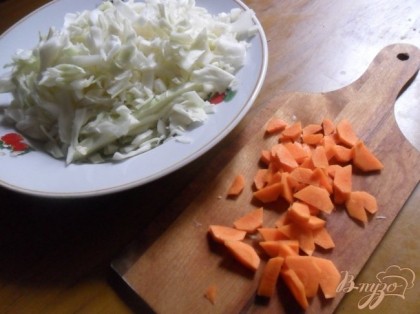 Капусту нашинковать, Очищенную и вымытую морковь нарезать ломтиками. В кастрюле довести до кипения 2,5 л воды. Заложить капусту, моковь и сладкий перец, очищенный от семян и нарезанный соломкой.