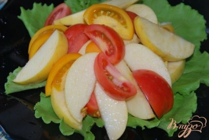 На салатные листья выкладываем помидоры и яблоко.