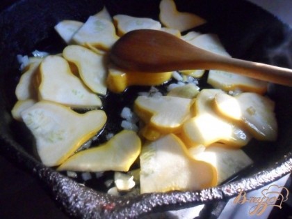 Разогреть в сотейнике (сковороде) масло и обжаривать в нём, помешива, лук, чеснок и кабачки 12 минут