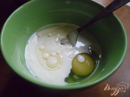 В другой миске взбить яйцо вместе с растительным маслом и кефиром.