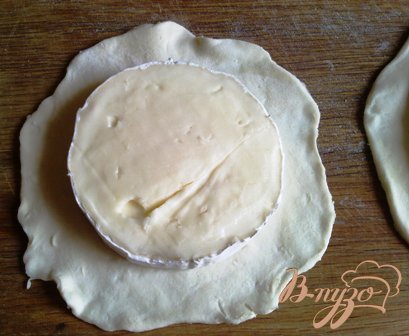 Сыр разрезаем пополам и выкладываем на большой круг теста срезом вверх.