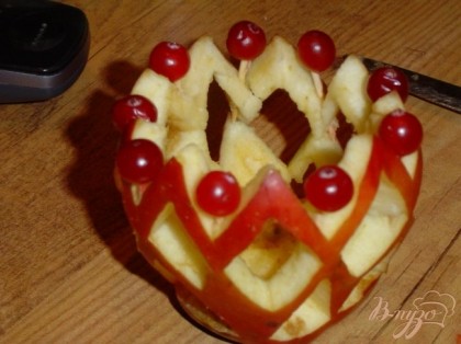 Верхний край яблока украшаем клюквой, нанизав ягоды на зубочистки