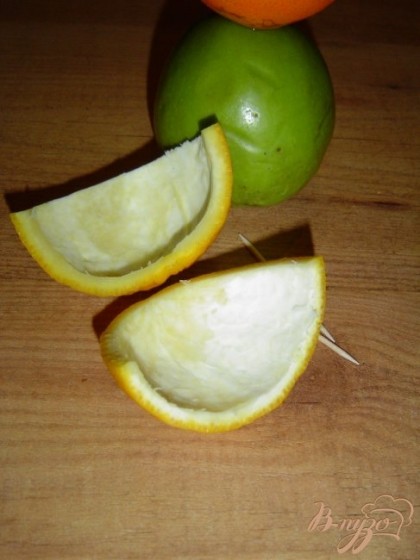 Апельсин разрезаем на две части, одну откладываем, а вторую половину режем пополам, убираем мякоть.