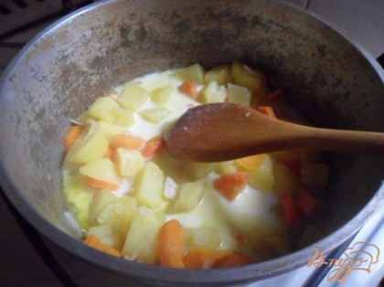 Картофель и морковь поместить в сотейник, залить водой так. чтобы покрывала, довести до кипения, посолить. Отварить до полуготовности. Добавить сливки, доведённые до кипения. Тушить до готовности.