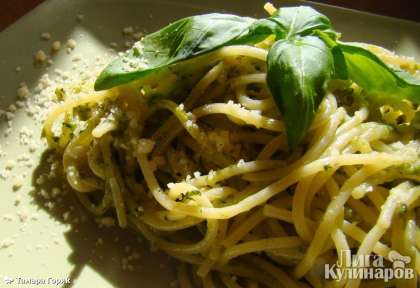 Спагетти перемешиваем с песто и даем немного пропитаться ароматами (минут 10). Затем выкладываем на тарелки и посыпаем оставшимся тертым Пармезаном.   Можно украсить листочками базилика.