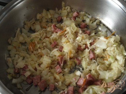 К луку и капусте добавить кусочки копчёной колбасы, также слегка поджарить.