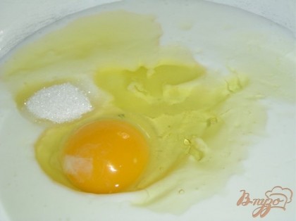 В кефир добавляем одно яйцо, сахар, соль и растительное масло, хорошенько перемешиваем.