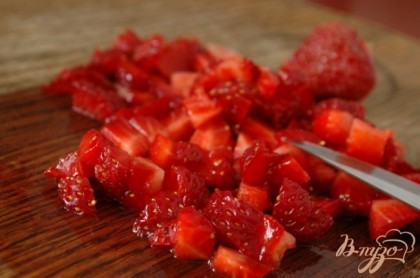 Удалить у клубники плодоножки, промыть ягоды и нарезать их кубиками.