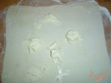Раскатываем тесто и на него выкладываем мягкий сливочный сыр и распределяем по всей поверхности теста.