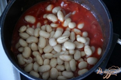 Добавить томаты в собственном соку. Если томаты были целыми, то нарезать их небольшими кусочками.Сцедить от жидкости и добавить готовую фасоль. Приправить солью, перцем, перцем чили. Варить соус 10 мин.