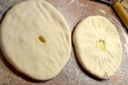Раскатать лепешку толщиной в 0,5-1 см. На середину лепешки положить заранее приготовленный фарш. Разровнять поверхность пирога, повернуть на другую сторону, так же разровнять. Повторить так 2-3 раза, пока пирогу не будет придана округлая форма и ровная толщина.