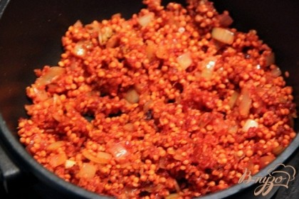 Добавить к луку томатное пюре, чечевицу, булгур и слегка потушить.