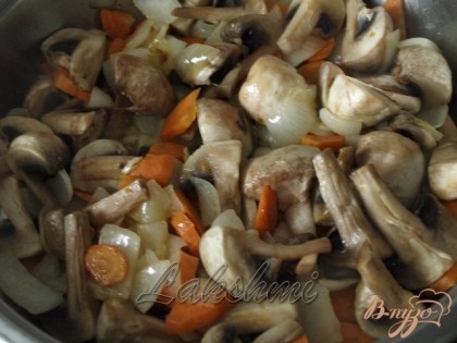 Разогреваем в сковороде растительное масло и обжариваем лук с морковью до золотистого цвета, добавляем шампиньоны и ещё немного обжариваем.