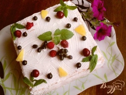 Покрыть взбитыми сливками бока и верх торта, нанести узор ( я наносила узор кисточкой). Сверху украсить торт фруктами и листиками мяты.