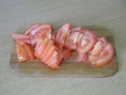 Свежие помидоры порезать дольками и выложить на тесто
