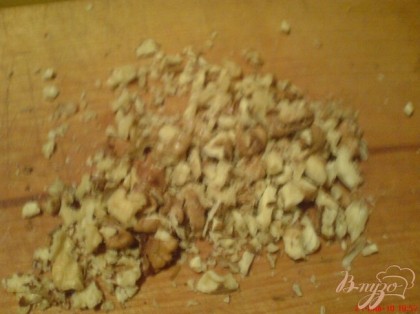 Грецкие орехи крупно порубите, отложите немного для посыпки.