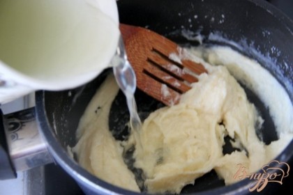 Маленькими порциями добавлять бульон, постоянно вмешивая его в масляно-мучную массу.