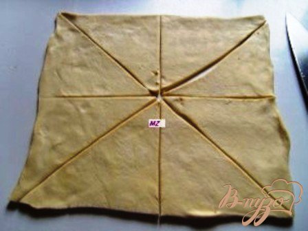 Размороженное тесто, слегка раскатав, разрезаем на треугольники.