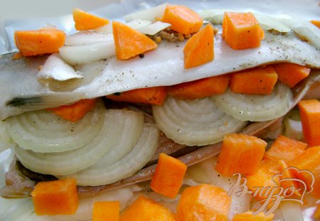 Каждую скумбрию внутри и снаружи натереть смесью специй-кумина, зёрен горчицы, соли, перца, натёртого мускатного ореха и разложить внутрь половину лука. На каждый лист фольги по количеству скумбрий положить оставшийся лук, на него рыбу, картофель и морковь.