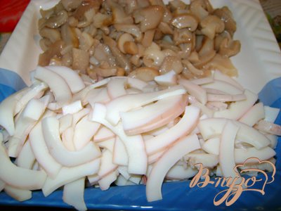 Нарезать кальмара соломкой, грибы дольками, крабовые палочки мелкими кубиками, лук измельчить,  белки трёх яиц нарезать так же, как и кальмара.