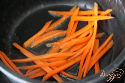 Морковь очистить и нарезать соломкой. Оливковое масло разогреть на сковороде и обжарить морковь до золотистого цвета.