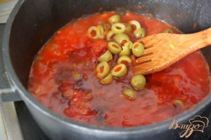 В сковороду вылить остаток масла и обжарить лук с чесноком.Добавить помидоры, ломая их ложкой. Добавить оливки, разрезанные напополам.Положите в соус корицу и сахар, влейте уксус. Количество сахара регулируйте по вкусу, тут все зависит от помидоров.